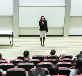 woman holding microphone standing in front of crowd