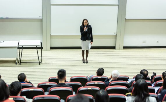 woman holding microphone standing in front of crowd