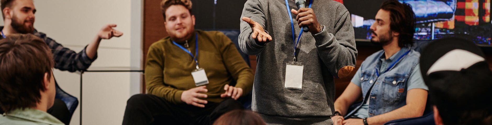 man in gray sweater talking to audience