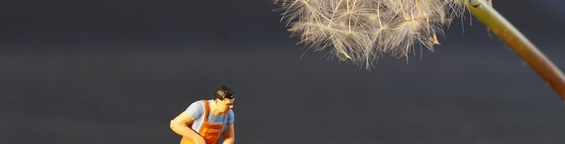 shallow focus photo of man holding floor brush ceramic figurine