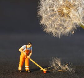 shallow focus photo of man holding floor brush ceramic figurine
