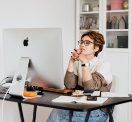 focused female employee reading information on computer in office
