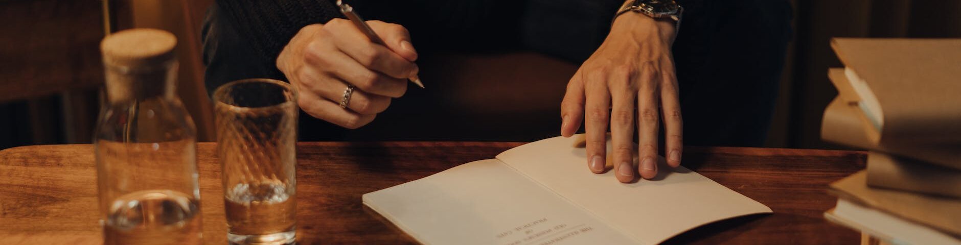 person in black long sleeve shirt holding white paper
