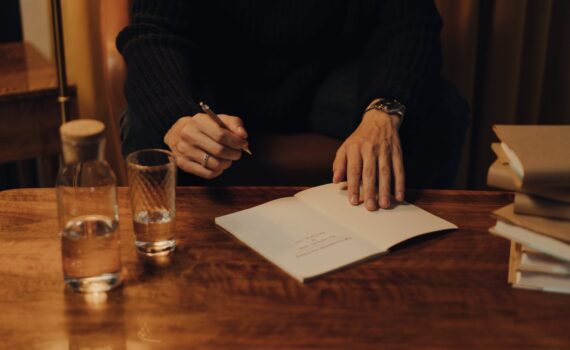 person in black long sleeve shirt holding white paper