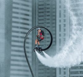 man in red jacket riding bicycle on white water wave