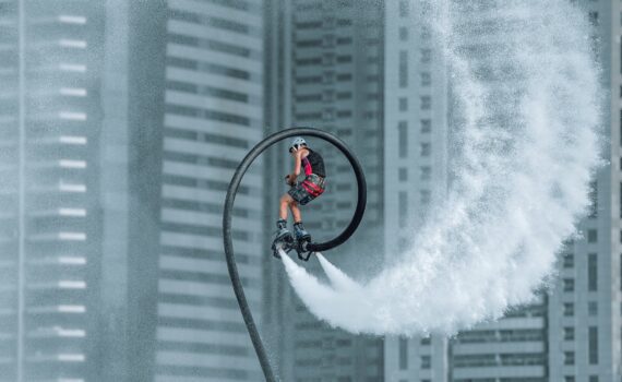 man in red jacket riding bicycle on white water wave