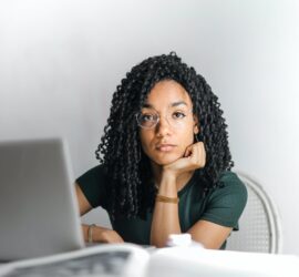serious ethnic young woman using laptop at home
