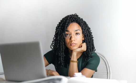 serious ethnic young woman using laptop at home