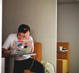 man in white shirt using macbook pro