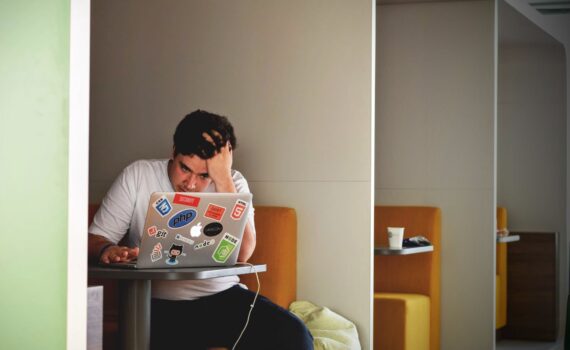 man in white shirt using macbook pro