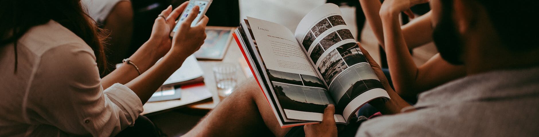 group of people reading book sitting on chair