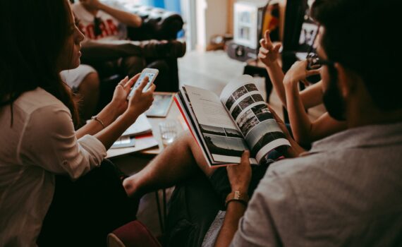group of people reading book sitting on chair